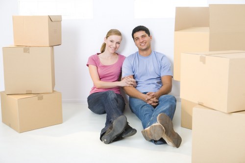 Movers carrying household items carefully through a property entrance